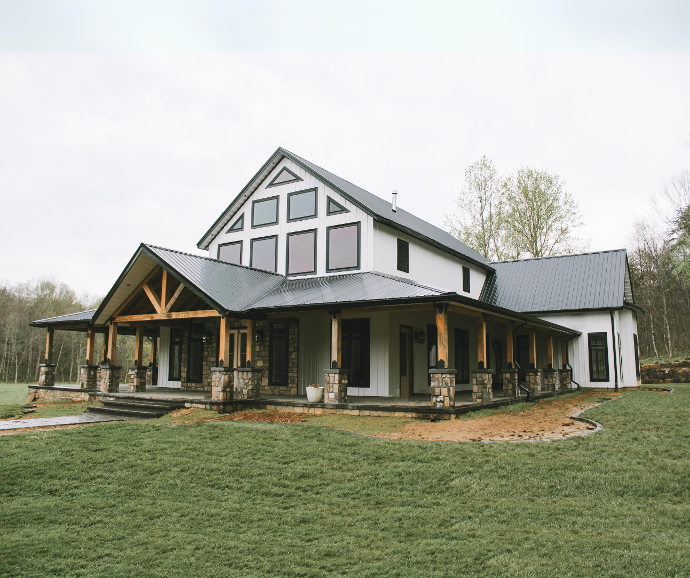 White home with black accents featuring vertical metal board and batten siding for a modern farmhouse-style exterior