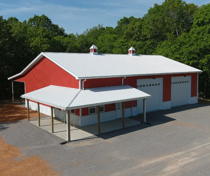 Bright red metal building with two large garage doors and dual red-and-white cupolas on the roof