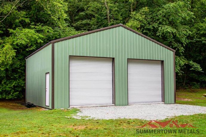 30x30x10 garage with green siding, brown trim, and two white garage doors