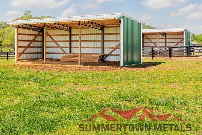 Larger run-in loafing shed with green siding, white accents, and lumber stored underneath