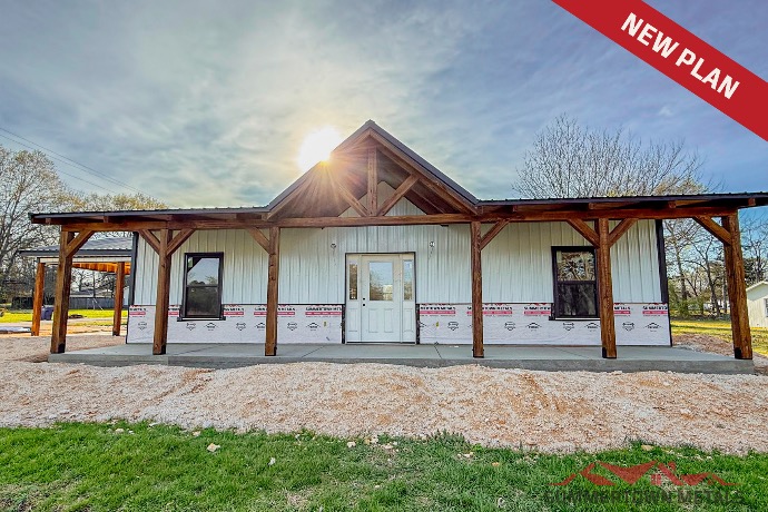 White-paneled Shady Meadows barndominium with carport, extended front porch, and dark black roof