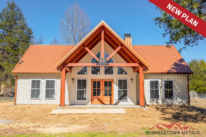 Cream-sided single-story Timber Crest barndominium with many windows and red roof