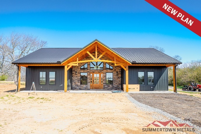 Single-level Piney Creek barndominium with dark siding, matching dark roof, wood and stone exterior accents, and single entry